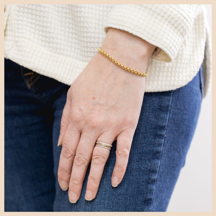 The Gold Box Chain Bracelet on wrist with stack rings. Based in Lexington, Kentucky