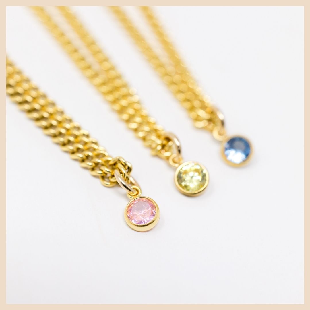 The Gold Curb Chain Birthstone Necklace 
October - Pink CZ, November - Topaz, December - Light Blue Sapphire Spinel.

Based in Lexington Kentucky

