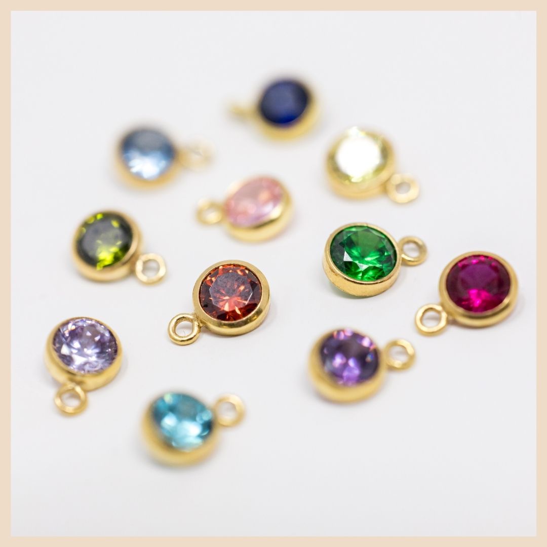 The Gold Curb Chain Birthstone Necklace 

Corundums: July - Red Ruby, September - Blue Sapphire

Cubic Zirconias: February - Amethyst, March - Aquamarine, May - Emerald, January - Garnet, June - Light Purple Amethyst, August - Peridot, October - Pink CZ, November - Topaz, April - White Clear CZ

Spinel: December - Light Blue Sapphire Spinel

Based in Lexington, Kentucky