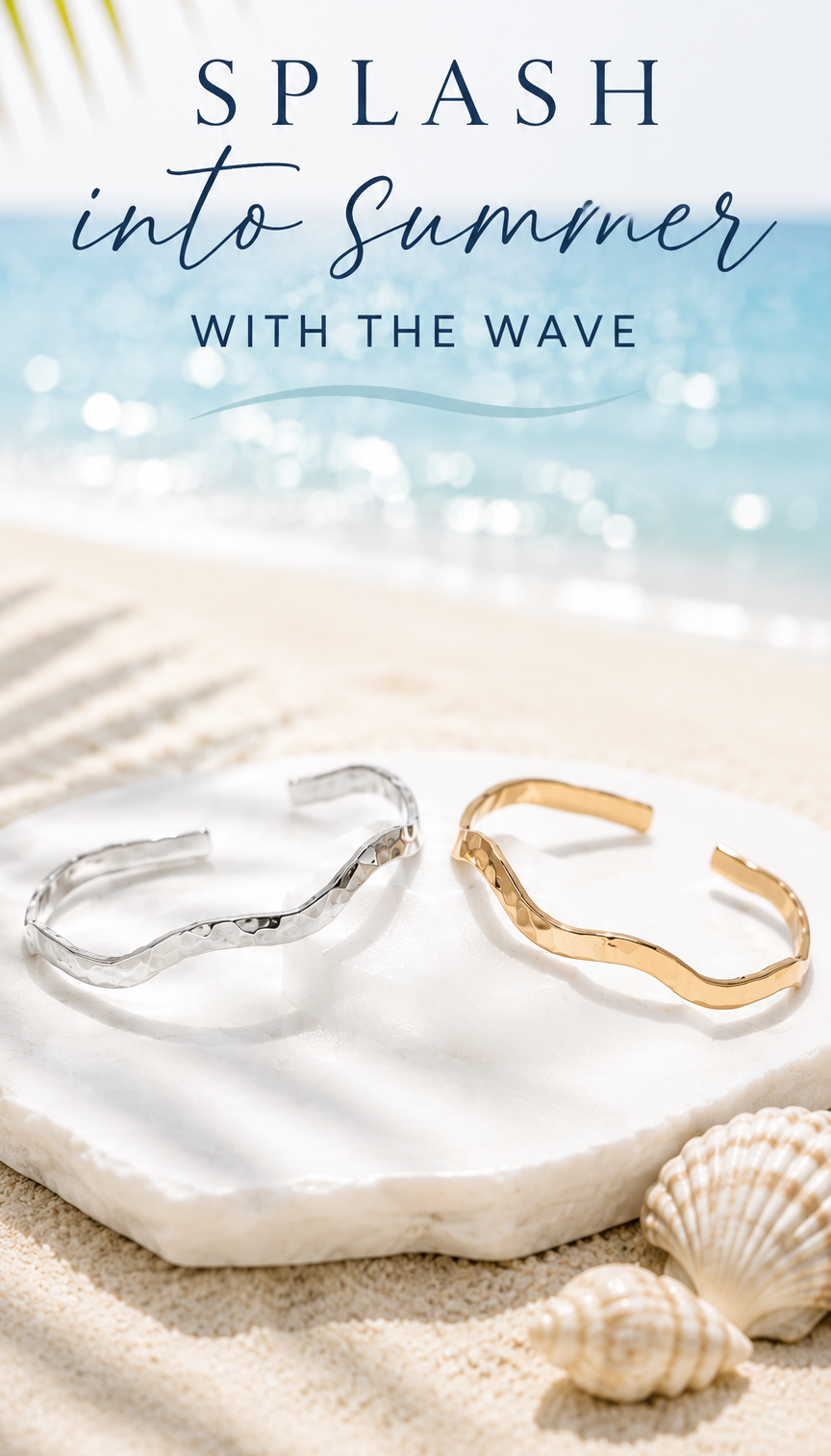 The Bold Wave Bangle Bracelet in sterling silver and gold sitting on the beach.